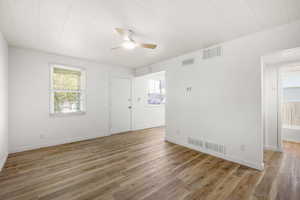 Empty room with a ceiling fan and light wood finished floors