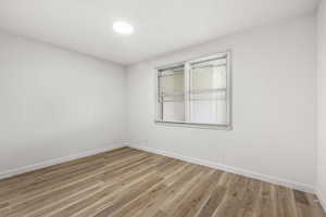 Spare room featuring light wood-type flooring and ornamental molding