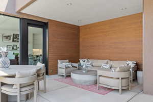 Living room featuring recessed lighting, wooden walls, and concrete floors