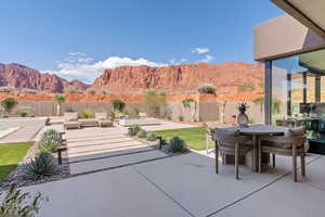 Fenced backyard featuring a mountain view, a patio, outdoor dining space, and an outdoor kitchen
