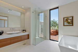 Bathroom with vanity, a shower stall, a wall of windows, a soaking tub, and recessed lighting