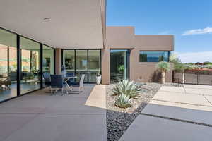 View of patio featuring a gate and outdoor dining space