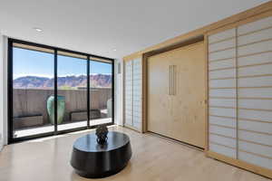 Foyer entrance featuring a wall of windows, a mountain view, wood finished floors, and recessed lighting