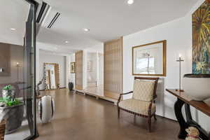 Sitting room with recessed lighting and concrete flooring