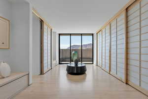 Living area with a wall of windows, a mountain view, and light wood finished floors