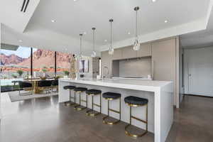 Kitchen with modern cabinets, a mountain view, floor to ceiling windows, recessed lighting, and a breakfast bar area