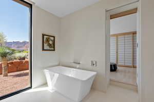 Full bath with a soaking tub, tile patterned floors, and a mountain view
