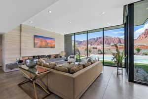 Living area with floor to ceiling windows, a mountain view, and recessed lighting
