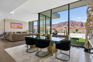 Dining area with a mountain view, floor to ceiling windows, recessed lighting, and concrete floors