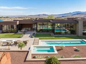 Rear view of property with a patio area, an outdoor pool, a mountain view, an in-ground hot tub, and a fire pit
