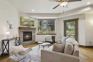 Living room featuring recessed lighting, a fireplace, wood finished floors, and a ceiling fan