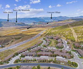 Aerial view of property's location with a mountainous background and nearby suburban area