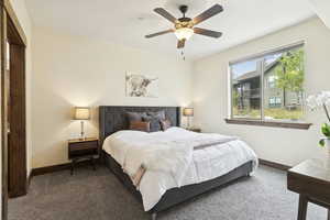 Carpeted bedroom with baseboards and ceiling fan