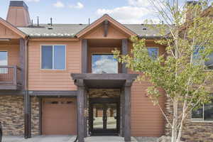 View of front facade featuring french doors, a balcony, and an attached garage
