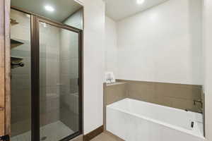 Bathroom with a garden tub, a shower stall, and recessed lighting