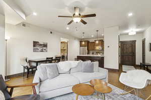 Living room featuring wood finished floors, a ceiling fan, recessed lighting, and washer / clothes dryer