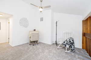 Living area featuring carpet, ceiling fan, and lofted ceiling