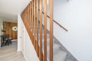 Stairway with wooden walls and wood finished floors