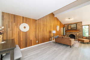 Living room featuring a fireplace, wooden walls, and light wood-type flooring