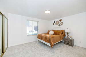 Bedroom featuring light carpet and a textured ceiling