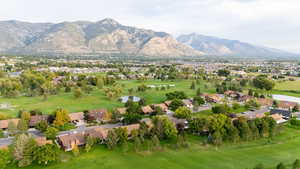 Aerial perspective of suburban area with a water and mountain view and a golf club