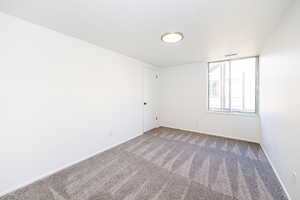 Empty room featuring carpet and baseboards
