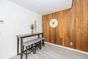 Dining room featuring light wood finished floors and wooden walls
