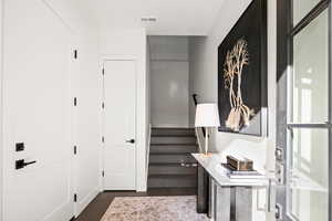 Hallway with stairway and dark wood-style flooring