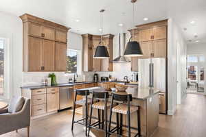 Kitchen with a kitchen bar, a center island, plenty of natural light, tasteful backsplash, and recessed lighting