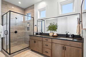 Full bath with a shower stall and double vanity