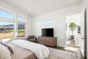 Bedroom featuring wood finished floors, multiple windows, recessed lighting, and a mountain view