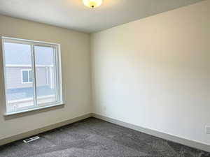 bedroom featuring baseboards and dark carpet