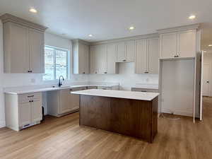 Kitchen with a center island, light wood-type flooring, recessed lighting, and light quartz countertops