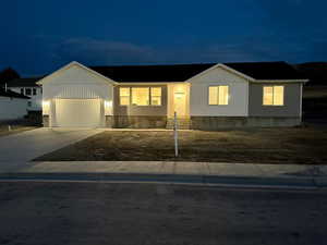 View of front of home with driveway, an attached garage, and board and batten siding
