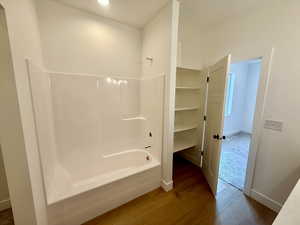 Full bath with wood finished floors and shower / bathtub combination