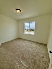 Bedroom featuring light colored carpet and baseboards