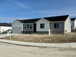 View of front of property featuring concrete driveway, a garage, and roof with shingles