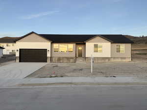 View of front of home with concrete driveway and a garage