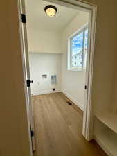 Laundry area right off garage with light wood finished floors and hookup for a washing machine