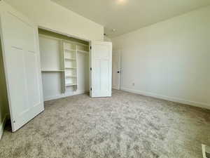 Bedroom featuring light colored carpet and a closet