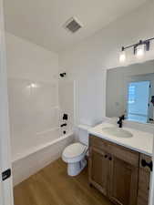 Full bath with vanity, bathing tub / shower combination, and light wood finished floors