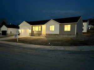View of front facade with concrete driveway and an attached garage
