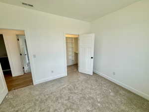 Bedroom featuring a walk in closet and carpet flooring