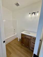 Bathroom with vanity, light wood-type flooring, and bathtub / shower combination
