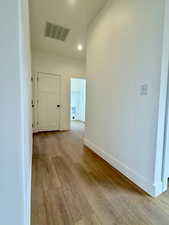 Hallway featuring light wood finished floors and recessed lighting