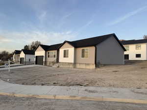 View of front facade featuring concrete driveway and an attached garage