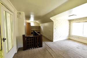 Bonus room with carpet flooring and lofted ceiling