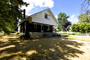 View of home's exterior featuring covered porch and a chimney