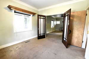 Entrance foyer with ornamental molding, carpet floors, and a ceiling fan