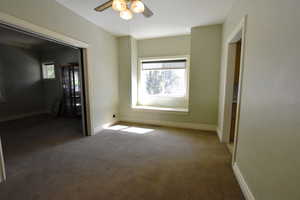 Carpeted empty room with baseboards and ceiling fan